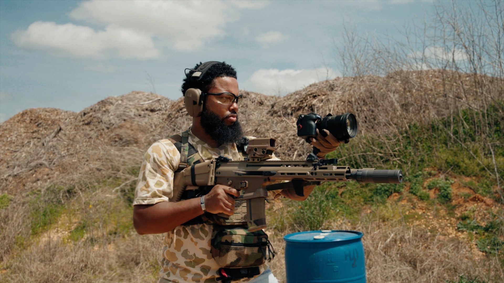 Stephon aiming a custom rifle with a camera mounted to the rail