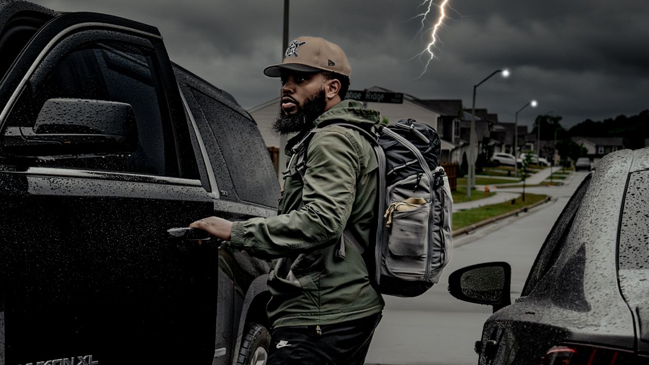 Stephon at his truck with a tactical pack as a storm rolls in